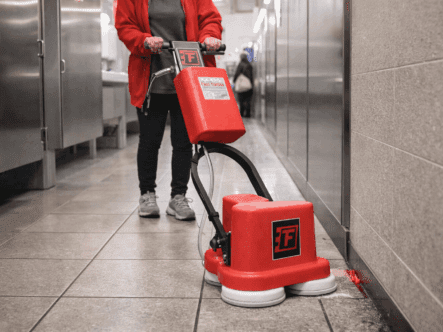 a custodian using the fas-edge in an airport bathroom.
