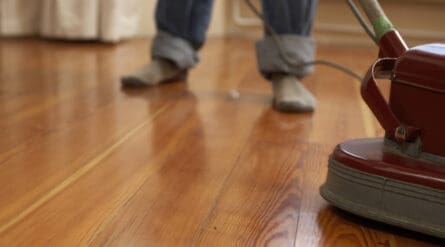 Polishing hardwood floor with scrubbing machine.