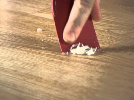 close shot of a scrubber removing wax from hardwood floor.